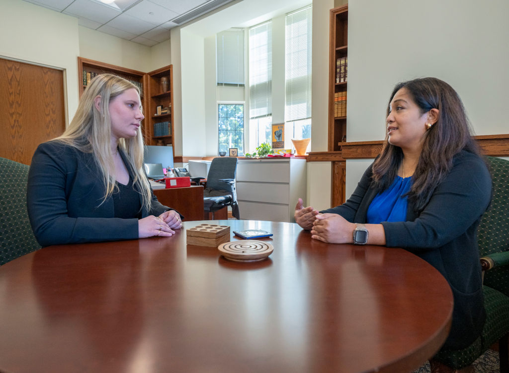 two female staff members at a table having a discussion